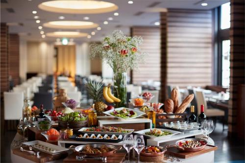 a buffet line with dishes of food and bottles of wine at Hotel Amsterdam Huis Ten Bosch in Sasebo