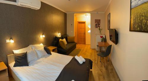 a bedroom with a bed and a living room at Angel's vendégház in Eger
