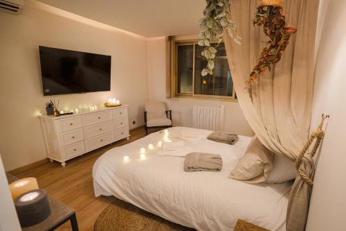- une chambre avec un lit blanc éclairé dans l'établissement Suite Romantique & Naturelle avec Balnéo, à Cholet