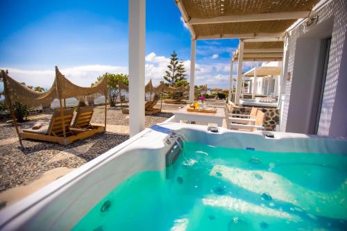 a jacuzzi tub in a house with a patio at Phaos Santorini Suites in Imerovigli