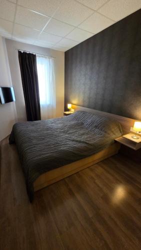 a bedroom with a bed with two lamps and a window at Dorka Apartman Zalakaros in Zalakaros
