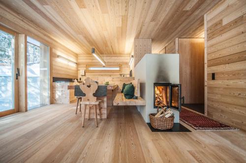a living room with a fireplace and wooden ceilings at Mountain Lodge Tamersc in San Vigilio Di Marebbe