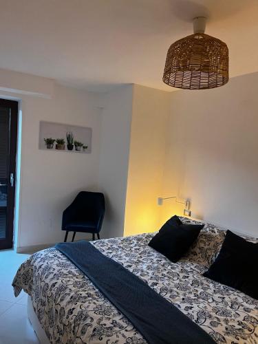 ein Schlafzimmer mit einem Bett, einer Lampe und einem Stuhl in der Unterkunft Castellabate Apartments Casa dell'Arco in Castellabate