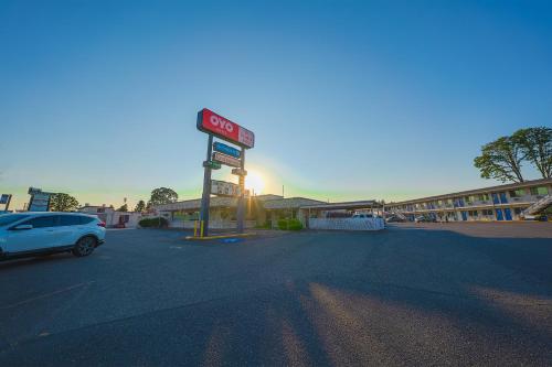 a sign for a gas station with a car parked at OYO Hotel St Helens OR in Saint Helens