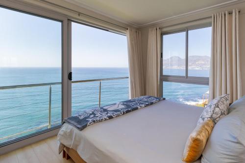 a bedroom with a bed and a large window at Sea Views Oceans Echo Villa in Fish Hoek