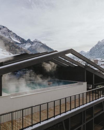 a hot tub on a building with mountains in the background at AMA Stay in San Vigilio Di Marebbe