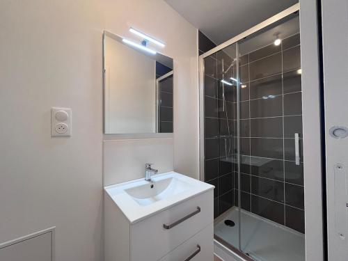 une salle de bain blanche avec un lavabo et une douche dans l'établissement 22 C Cozy and Convenient, à La Roche-sur-Yon