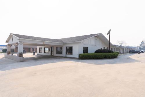 a large white building with a parking lot at OYO Hotel DeRidder Hwy 171 North in DeRidder