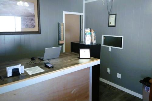 a office with a desk with a laptop and a monitor at Love Hotels Desert Inn & RV by OYO at Boysen Wind River WY in Shoshoni