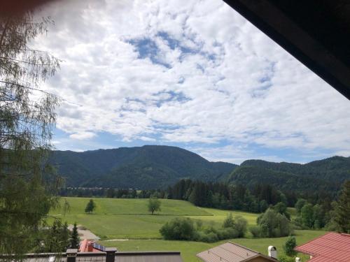 a view of a green field with mountains in the background at Gästehaus Tanneck in Reit im Winkl