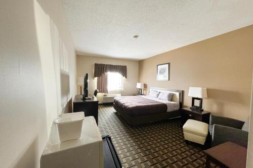a hotel room with a bed and a couch at FairBridge Inn & Suites Batavia-Darien Amusement Park in Batavia