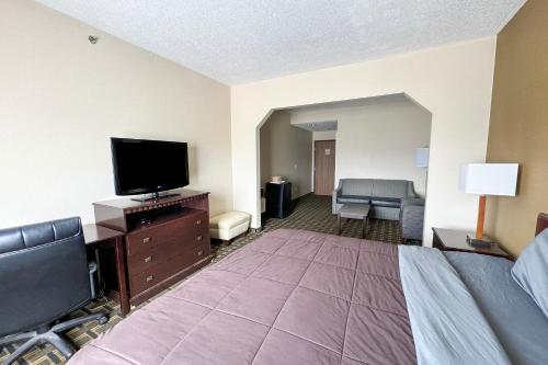 a hotel room with a bed and a flat screen tv at FairBridge Inn & Suites Batavia-Darien Amusement Park in Batavia