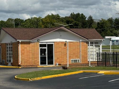 un edificio de ladrillo con un estacionamiento delante de él en Travel Inn By OYO Danville US-29, en Danville