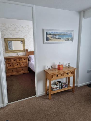 a bedroom with a mirror and a wooden table at 200 Breakaway Chalet in Scratby