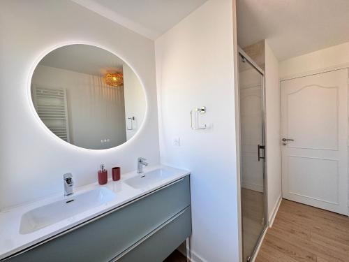 une salle de bain avec un lavabo et un miroir dans l'établissement Le Charme - Jardin - Petanque - Parking - 6p, au Mans