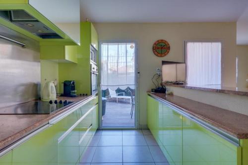 - une cuisine avec des murs verts et un comptoir dans l'établissement 