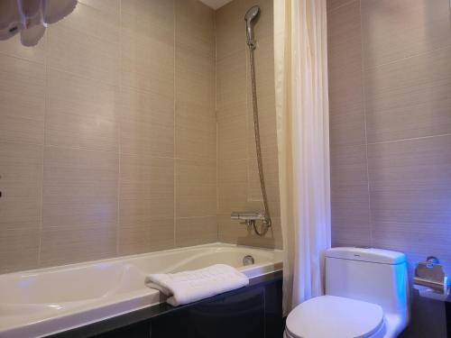 a bathroom with a tub and a toilet and a sink at Luxeden Hotel Hanoi in Hanoi