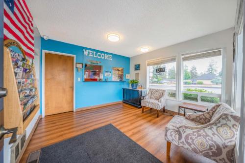 ein Wohnzimmer mit blauer Wand und einem Willkommensschild in der Unterkunft Royal Gateway Motel by OYO in Bend