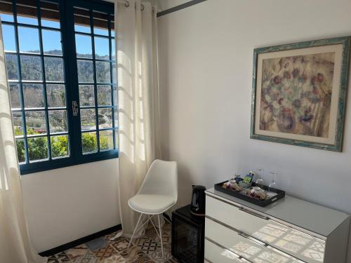 Cette chambre blanche dispose d'une chaise et d'une fenêtre. dans l'établissement Chez Montiz, à Montazels