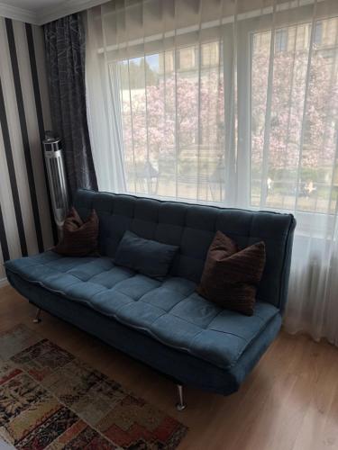 a blue couch in a living room with a window at Apartments an der Caracalla Therme in Baden-Baden