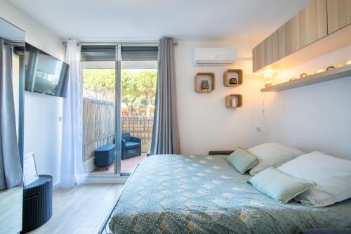 une chambre avec un lit et un balcon dans l'établissement Le Cabestan Studio Terrasse Parking Proche de la plage et de la Marina de Port Camargue, au Grau-du-Roi