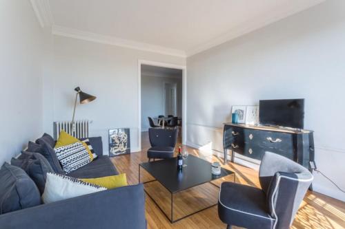 a living room with a couch and chairs and a table at GuestReady - Designer Apartment - Eiffel Tower View! in Paris