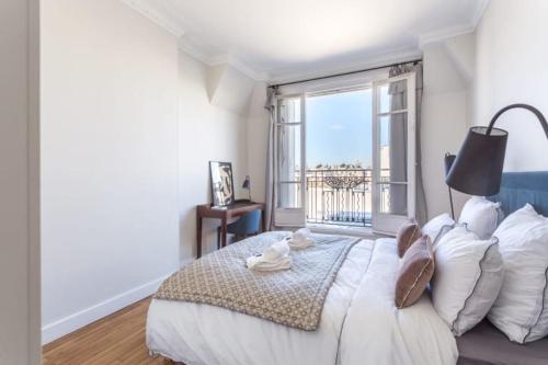 een slaapkamer met een groot bed met een groot raam bij GuestReady - Designer Apartment - Eiffel Tower View! in Parijs