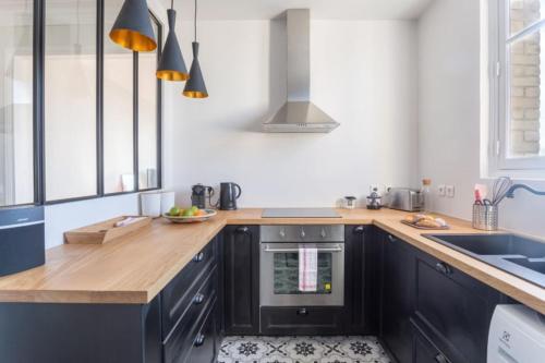 een keuken met een houten aanrecht en een oven bij GuestReady - Designer Apartment - Eiffel Tower View! in Parijs