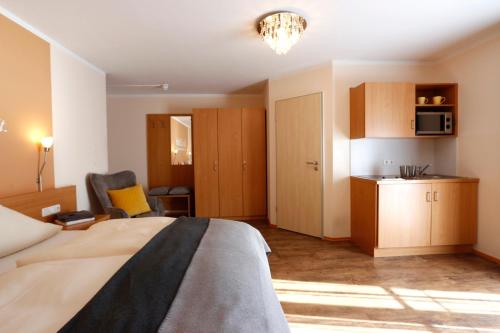 a hotel room with a bed and a kitchen at Gästehaus Zehmerhof bei Erding in Walpertskirchen