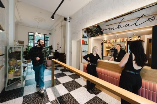 a group of people standing at a counter in a restaurant at Wombat's City Hostel Leipzig in Leipzig