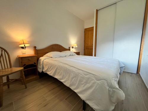 une chambre avec un lit, une table et une chaise dans l'établissement Appartement lumineux avec piscines, terrasse et parking à Samoëns - FR-1-624-125, à Samoëns