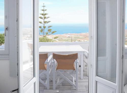 a dining room with a table and a view of the ocean at Phaos Santorini Suites in Imerovigli