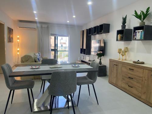a living room with a table and some chairs at New 3 Bed Apt with Communal Pool in St Paul's Bay