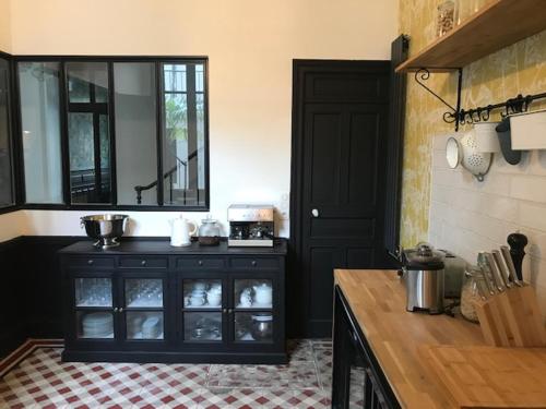 a kitchen with a counter and a cabinet with a mirror at Maison Caju - La Rochelle in La Rochelle
