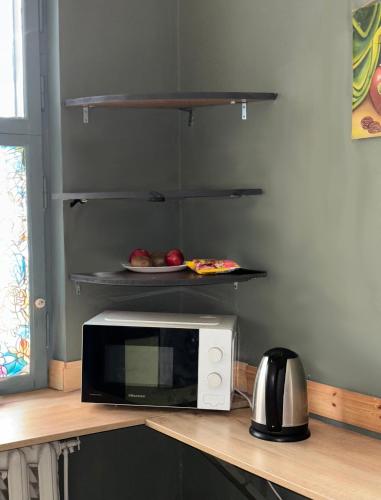a microwave on a counter with a plate of fruit at Chisinau Hostel in Chişinău