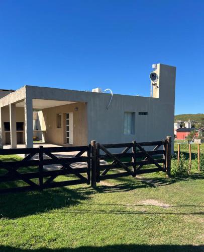 una recinzione di legno di fronte a una casa di Cabañas Valle del Búho a Potrero de los Funes