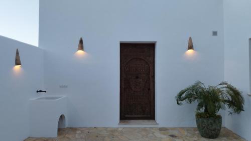 einen Flur mit Tür und Topfpflanze in der Unterkunft Casa Anna in Facinas