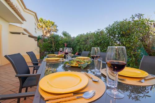 a table with plates of food and wine glasses at Villa Tropical Oasis Park in Portimão