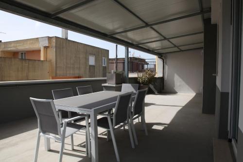 a white table and chairs on a balcony at Bernaldabella Penthouse Your Holiday Home near Matera in Bernalda