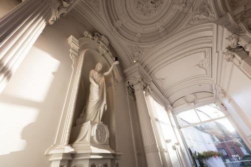 a statue of a woman in a room with a window at Hotel Gravensteen in Ghent