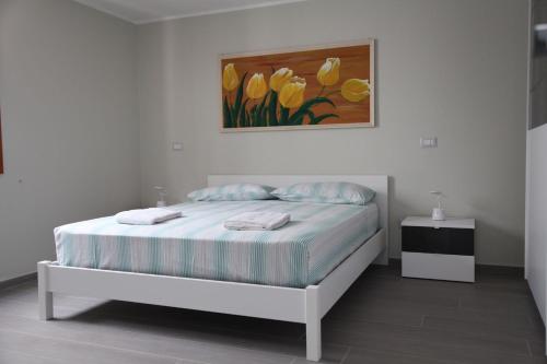 a bedroom with a bed with a painting on the wall at Bernaldabella Penthouse Your Holiday Home near Matera in Bernalda
