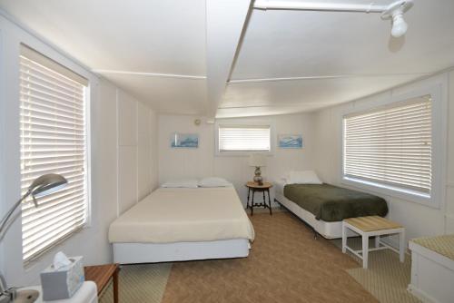 a bedroom with two beds and two windows at 337CA 337 Catalina in Avalon