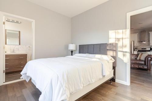 a white bedroom with a large bed and a bathroom at Bright & Cozy Jersey City Retreat in Jersey City