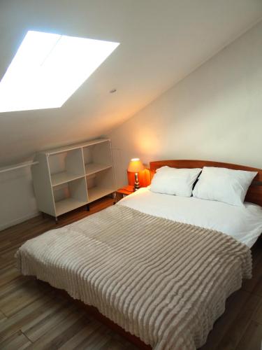 une chambre avec un grand lit avec une lucarne dans l'établissement Appartement sous les combles, à Rezé