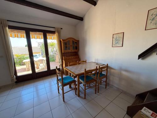 une salle à manger avec une table et des chaises en bois dans l'établissement Villa 4/6 pers. au calme, proche port, parking privé - FR-1-784-39, à Gruissan