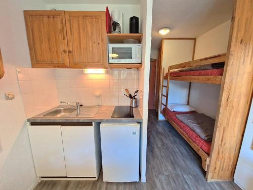 Il comprend une petite cuisine avec un évier et des lits superposés. dans l'établissement Studio cosy 4 pers, 20m², balcon, proche pistes et commerces, Modane - FR-1-265-201, à Valfréjus
