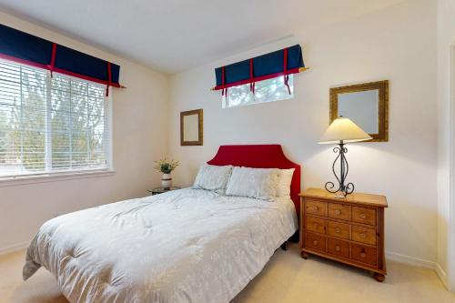 a bedroom with a bed and a lamp and windows at Eagle Crest Nature Retreat in Redmond