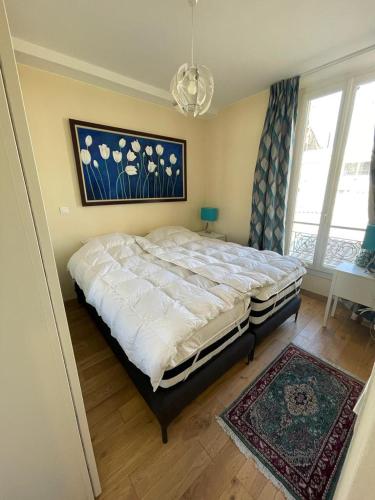 une chambre avec un grand lit et un tapis dans l'établissement Centre Cannes Pradignac, à Cannes