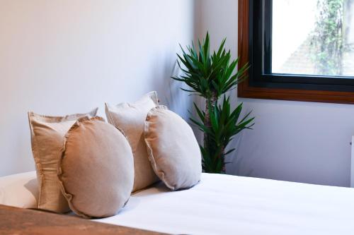 a group of pillows sitting on top of a bed at Estudio by Celta Home in Vigo