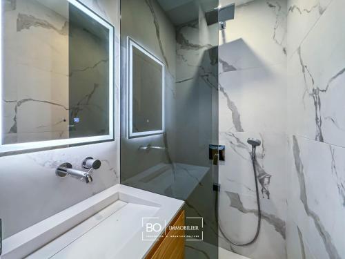 une salle de bain avec une douche, un lavabo et un miroir dans l'établissement Studio Pâquier - Lac d'Annecy, à Annecy